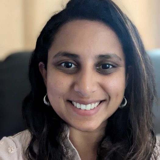 Portrait photo of Swetha. Swetha is looking at the camera and smiling