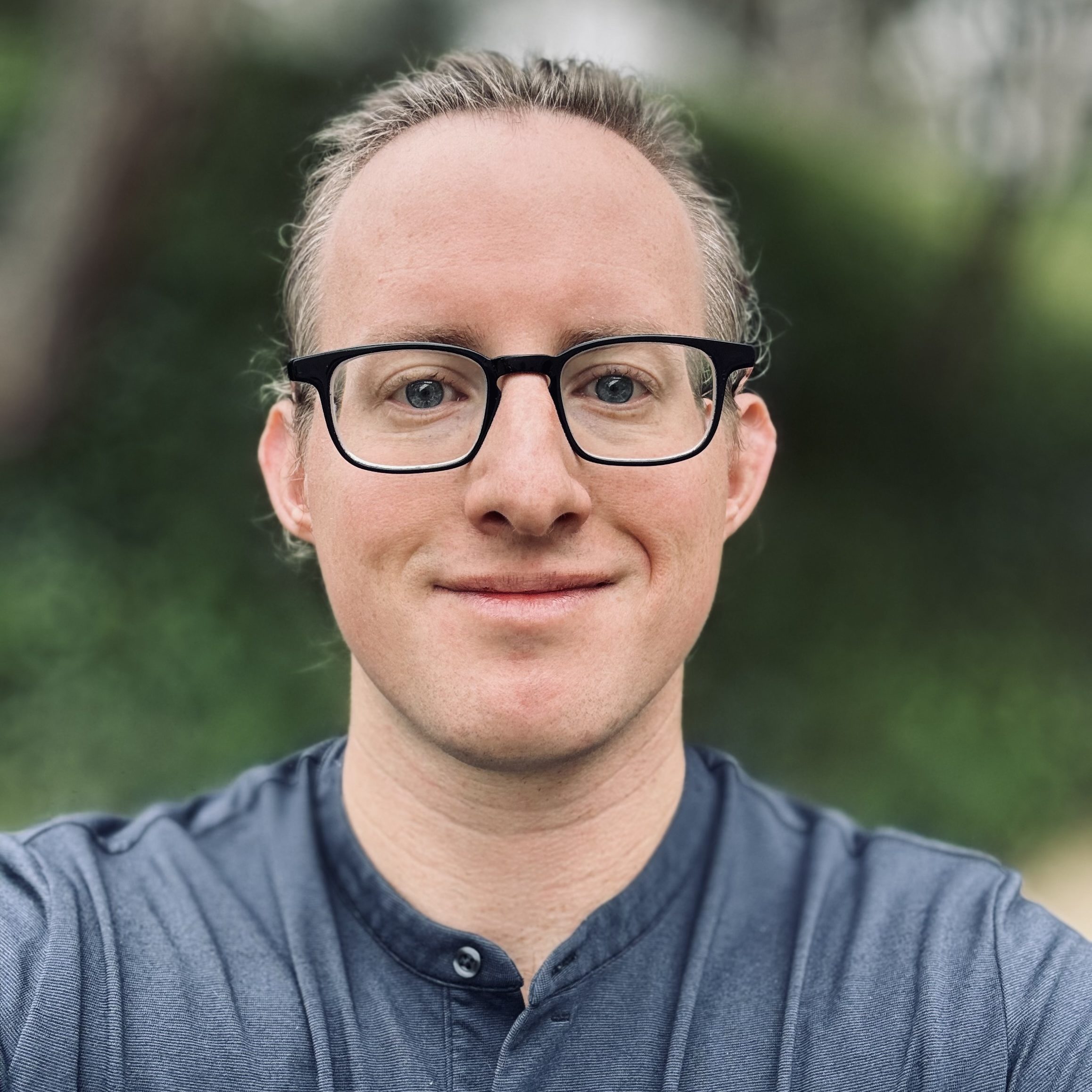 Portrait photo of Greg . Greg is looking at the camera and smiline